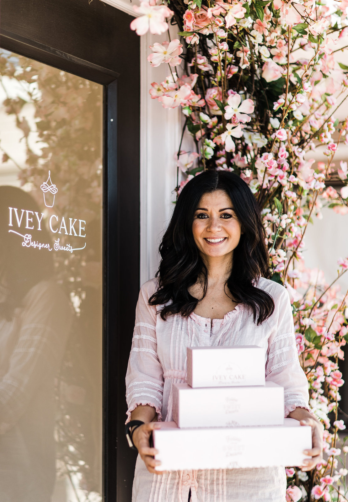 Ivey Cake owner holding bakery boxes